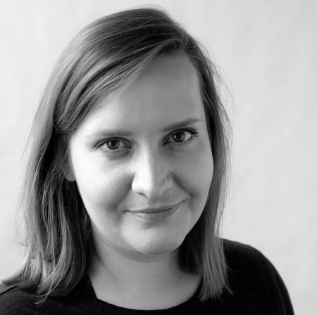 Portrait of Soňa Morgenthalová. A person with shoulder-length hair against a white background smiles friendly into the camera.