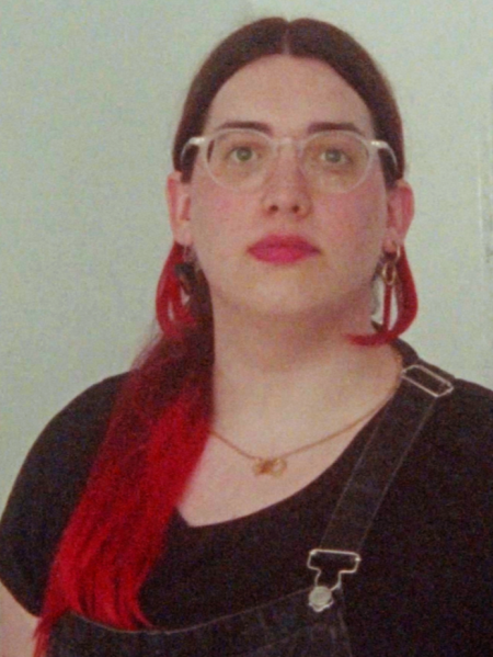 Paula Tomás Marques in Portrait. A Person with long red hair and glasses.